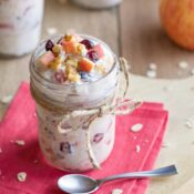 One jar of Oats on a pink napkin with extra apples and a few oats for decoration.