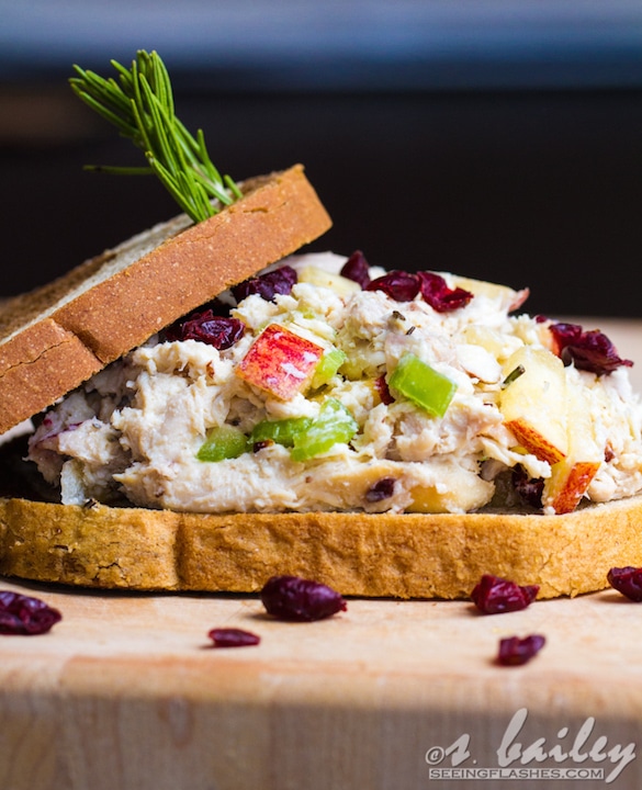 Side view of chicken salad sandwich with top bread slid back so you can see filling.