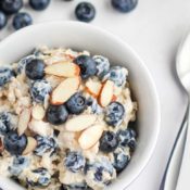 Overhead photo of the finished recipe, presented in a little single-serving bowl with a spoon and additional blueberries around the edges of the photo.