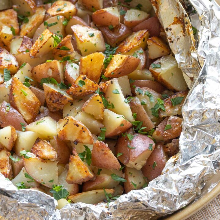 Closeup of potatoes in foil pack that's been rolled open.