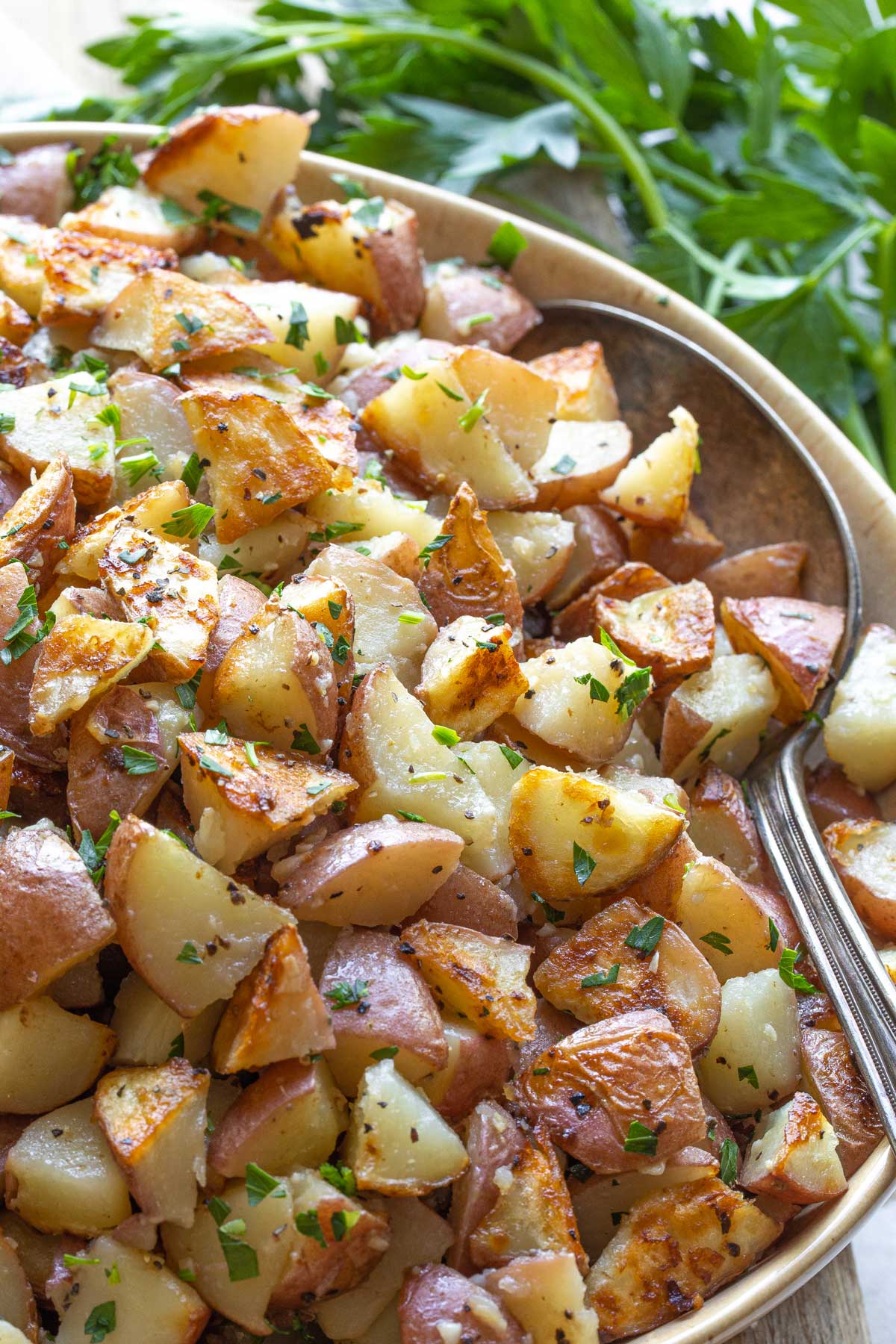 Closeup of potatoes in serving bowl, with antique spoon tucked into the side.