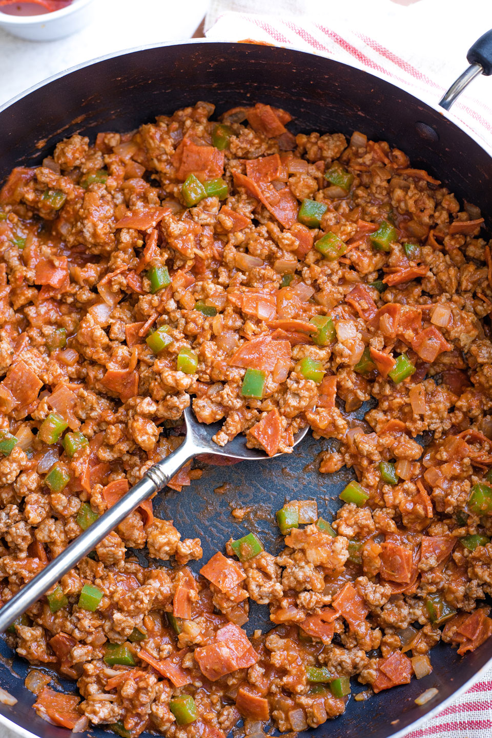 Spoon stirring Italian sauce into filling.