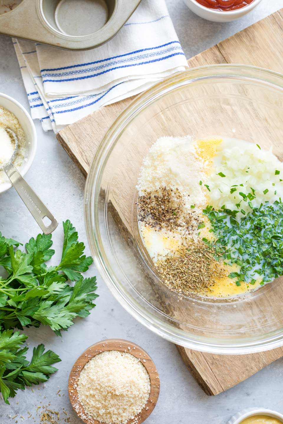 Onions, cheese and seasonings added to beaten egg in mixing bowl.