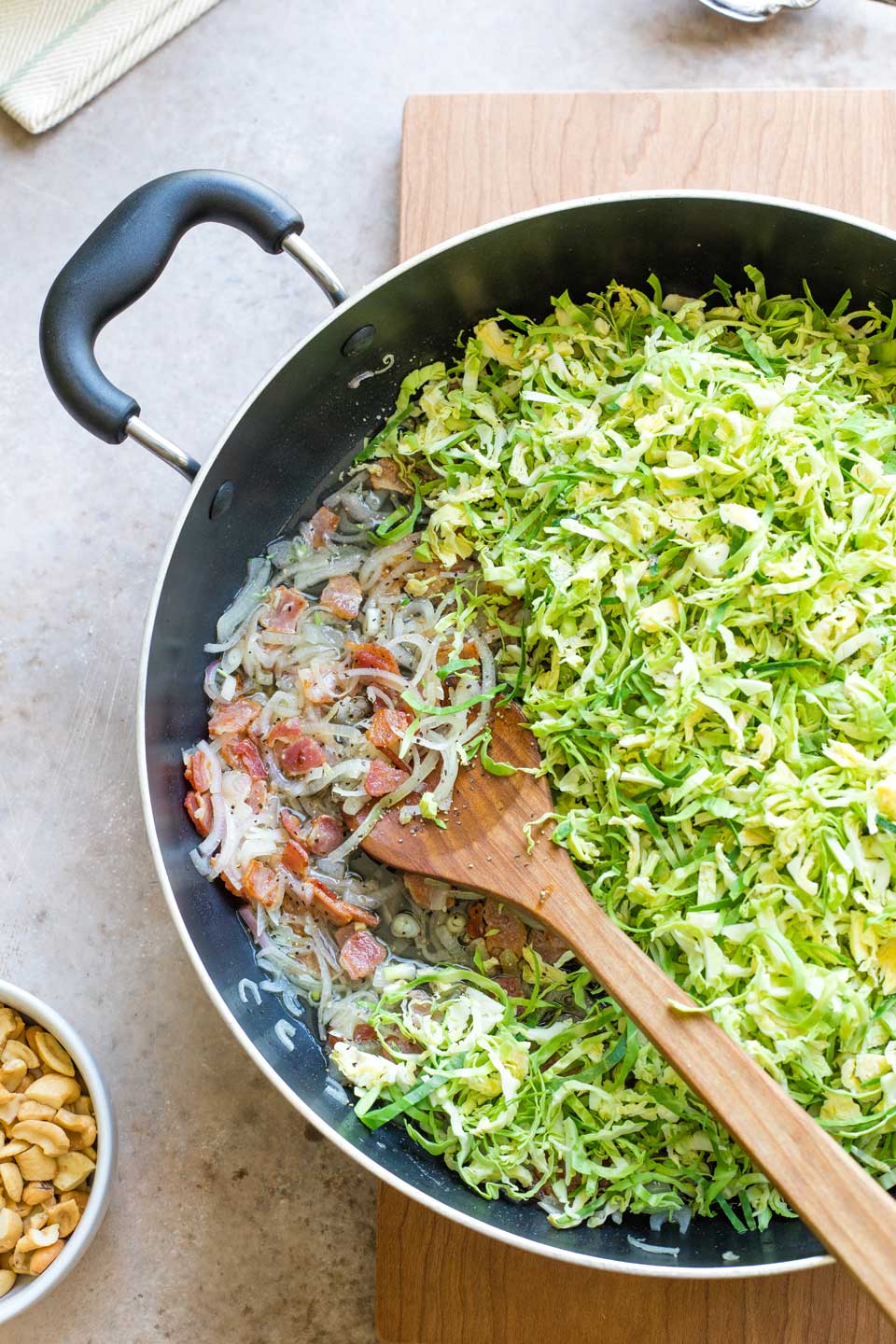 Shallots, sauce, bacon and Brussel sprouts in pan before sprouts are sauteed.