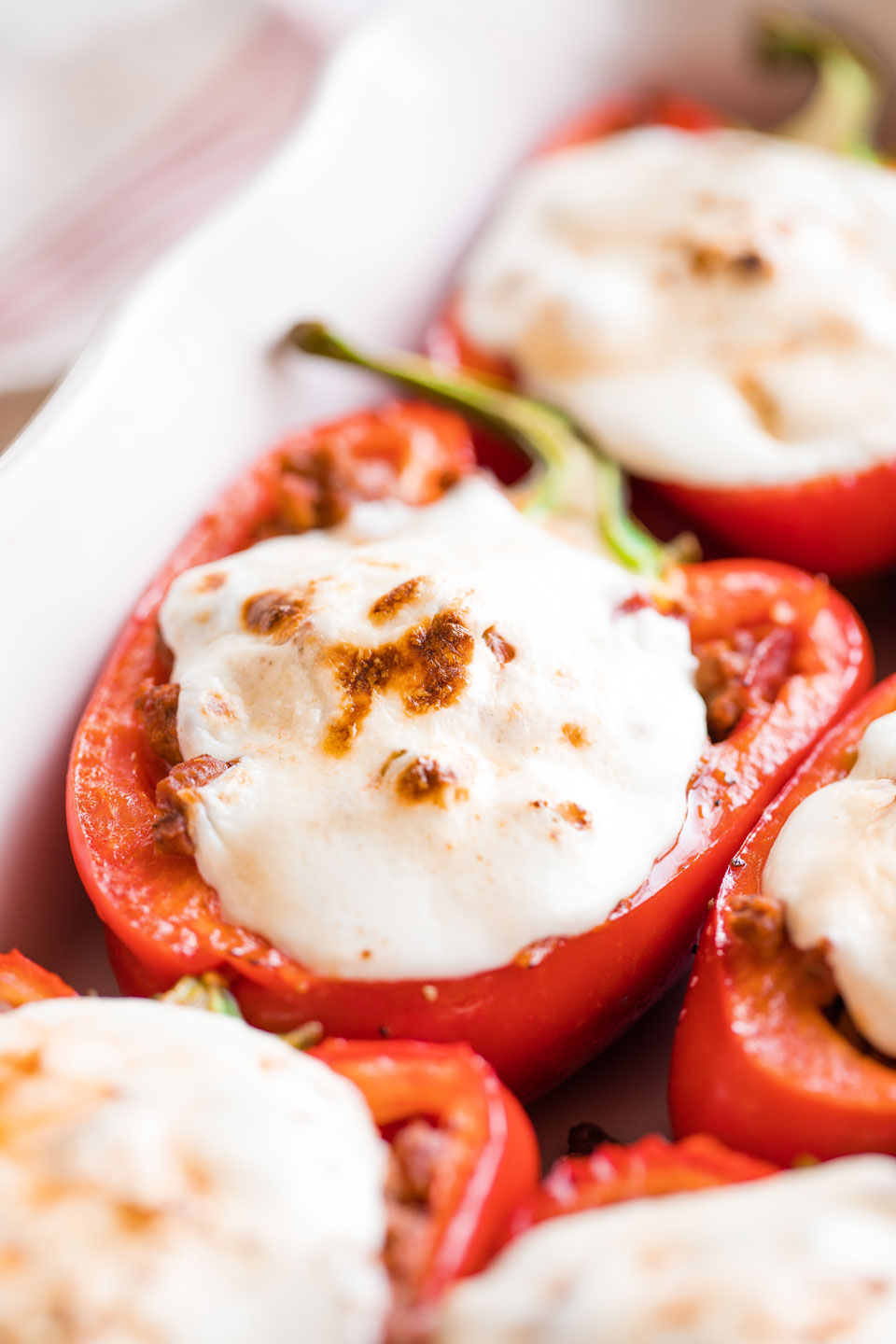 Closeup of one stuffed Italian pepper still in baking dish.