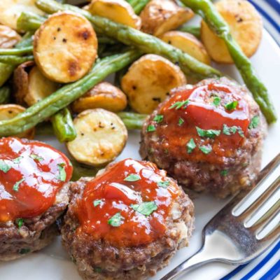 Closeup of 3 served with vegetables, with a fork tucked alongside.