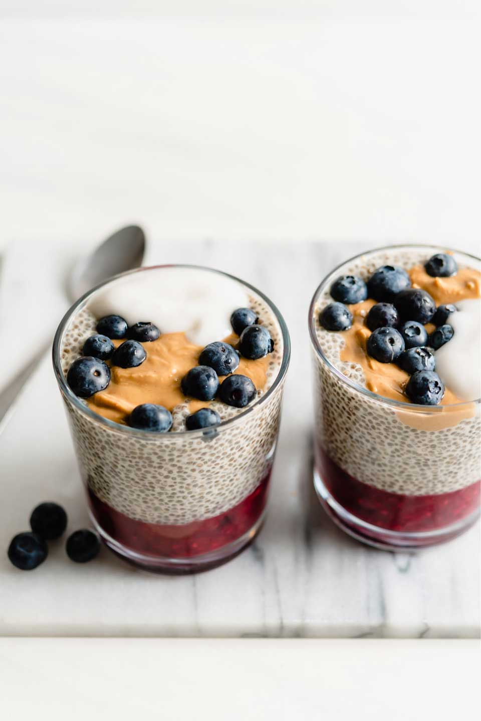 Glasses with jelly in the bottom, then chia pudding, then dollops of peanut butter and yogurt with fresh blueberries.