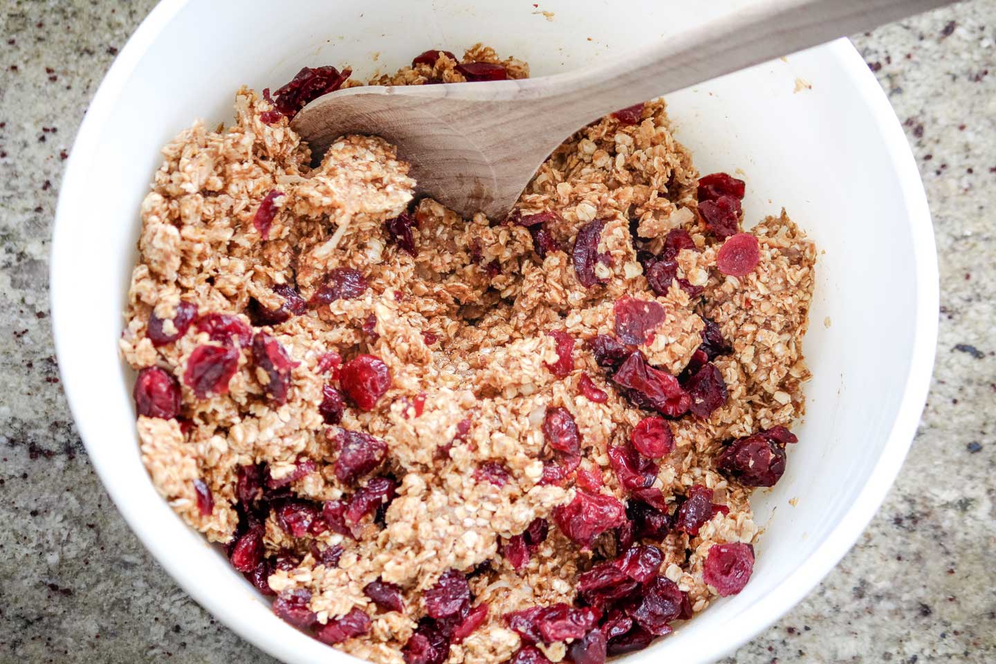 REcipe ingredients mixed together with a wooden spoon, ready to be shaped into Energy Balls.