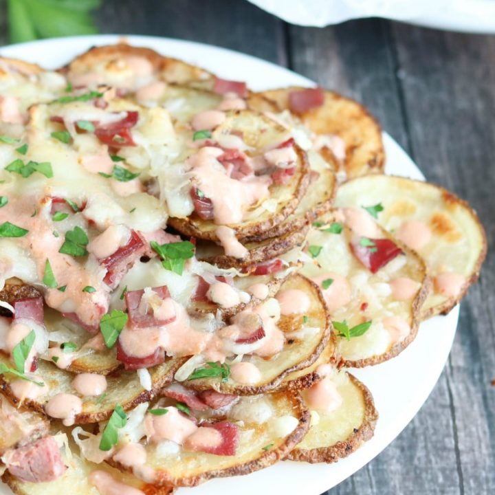 Closeup of portion of Irish nachos on right side of white plate.