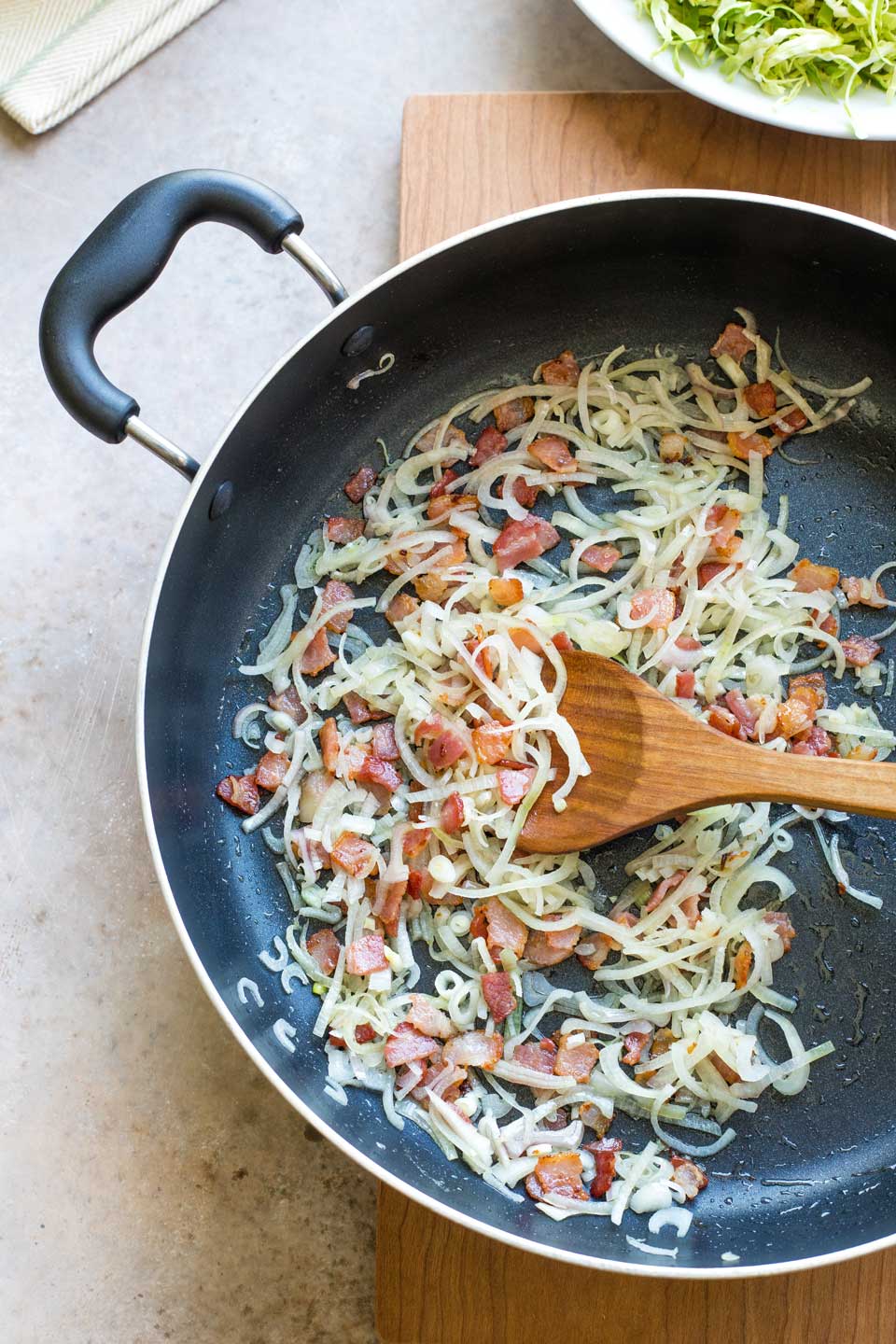 Sauteed bacon and shallots in plan before Brussel sprouts are added.