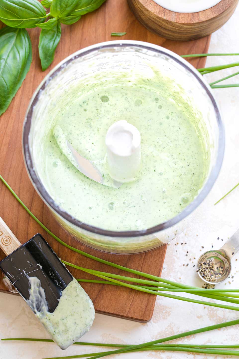 Overhead of the smoothly blended, light green tzatziki sauce in the food processor, before the cucumber is added.